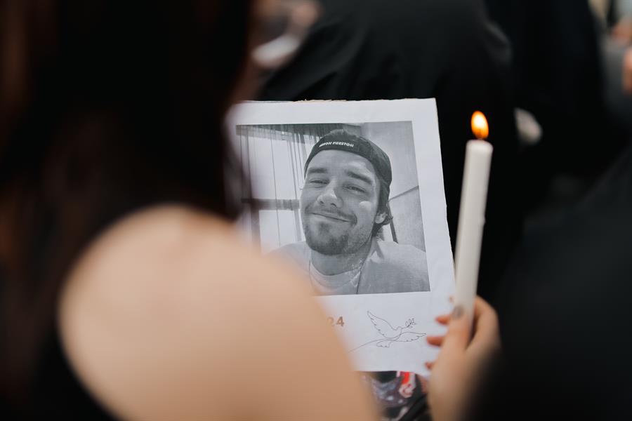 Una fanática sostiene una foto del cantante Liam Payne, durante un homenaje al artista en el Obelisco en Buenos Aires./ EFE