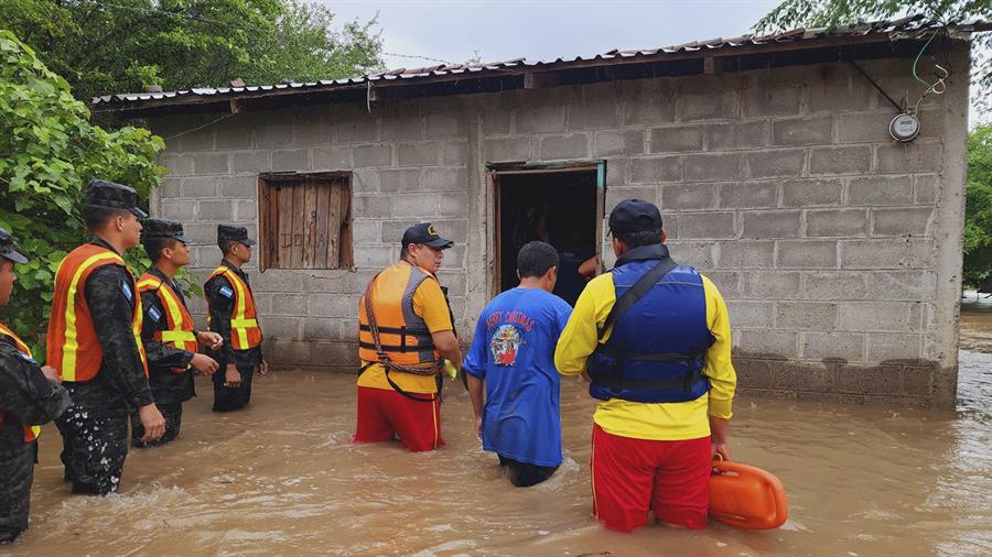 Foto cedida el 17 de junio de 2024 por Bomberos de Honduras que muestra a varios de sus miembros mientras hacen un recorrido por inundaciones tras el desbordamiento de un río en la comunidad de Playa Grande. /EFE