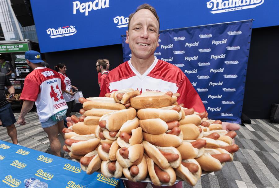 Joey Chestnut sostiene un plato de 76 hot dogs en una foto de archivo. /EFE