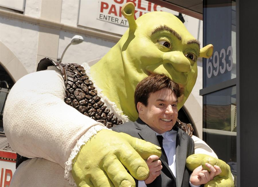 Fotografía de archivo del 20 de mayo de 2010 de una caracterización de Shrek (atrás), la estrella de la famosa saga homónima, y el actor que le de la voz, Mike Myers./ EFE