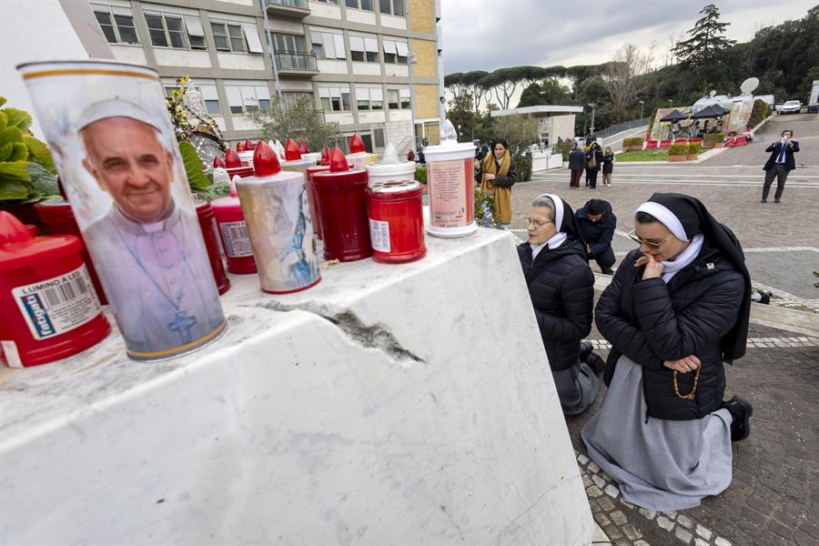 Dos monjas rezan bajo la estatua del Papa Juan Pablo II, en el policlínico Gemelli, donde el Papa Francisco está hospitalizado./ EFE