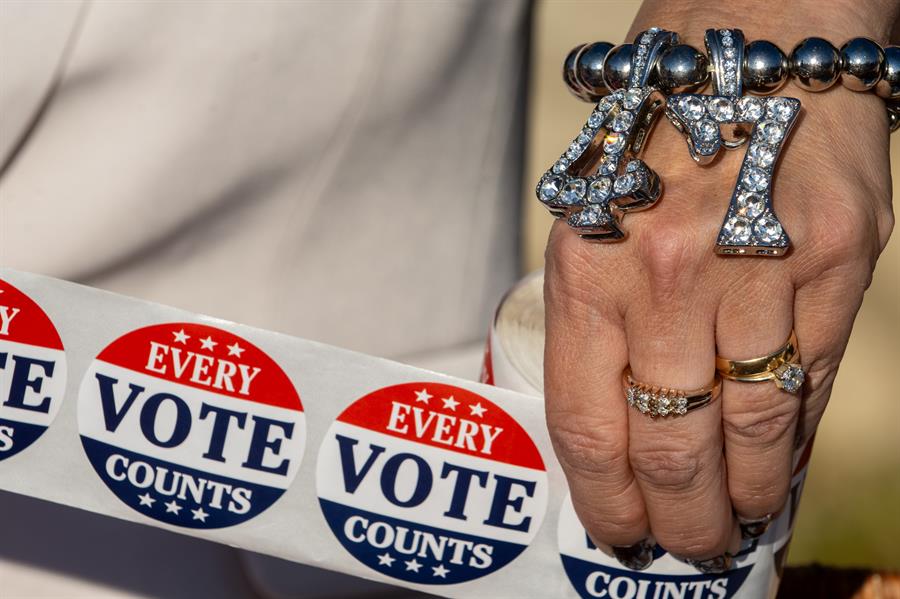 Un partidario de Trump que lleva una pulsera con la leyenda "47" sostiene pegatinas con la leyenda "Cada voto cuenta"./ EFE