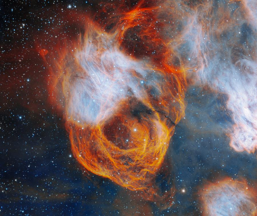 Con tenues capas en rojo, naranja y amarillo, la nebulosa que encierra a NGC 2040 se asemeja a una vibrante rosa. /EFE