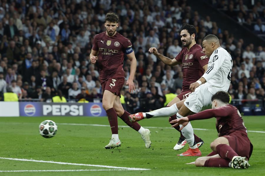 El delantero francés del Real Madrid, Kylian Mbappé (2d), remata ante los defensores del Manchester City./ EFE